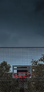 Outdoor basketball hoop under dark evening sky.