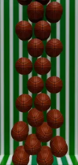 Basketballs rolling down a green striped surface.