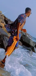 Man exploring rocky beach with ocean waves.