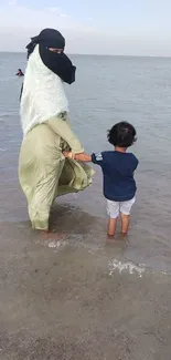 Mother and child enjoying a serene beach moment.