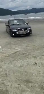 Car driving on a sandy beach with ocean view.