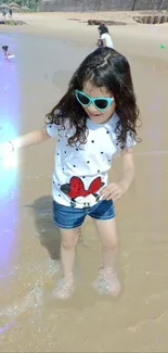 Child enjoying a playful day at the beach in sunglasses and casual wear.