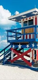 Patriotic lifeguard tower on a sunny beach with blue skies.