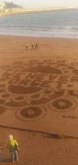 Sandy beach with intricate sand art and inspirational text in the center.