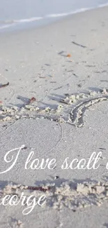 Beach sand heart art with ocean waves.