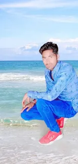 Person in blue outfit on a beach with ocean backdrop.