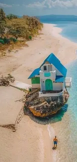 Aerial view of beach with blue-roofed house.