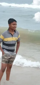 Person walking along the beach with waves in the background.