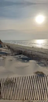 Beach sunset with sandy dunes and ocean waves, perfect phone wallpaper.