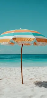 Vibrant beach umbrella on sandy shore with ocean view.