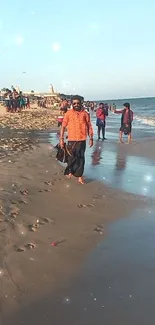 Man walking on a beach with ocean waves during sunset.