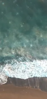 Aerial view of ocean waves meeting the sandy beach.