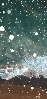 Aerial view of a teal ocean with waves and falling snow on the beach.