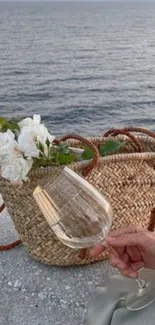 Elegant seaside scene with wicker basket, wine glass, and ocean view.