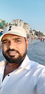 Beachfront selfie with ocean and clear sky in the background on a sunny day.