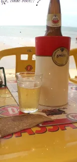 Beachside table with beer and sea view, perfect for relaxation.