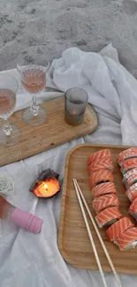 Sushi and wine setup on beach sand.