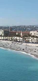 Beach cityscape with turquoise sea and vibrant town under blue sky.