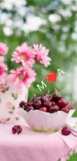 Pink flowers and cherries in a bowl on a table.