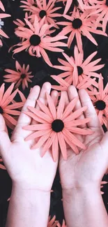 Hands holding vibrant coral flowers with dark leaves.