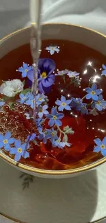 Cup of tea with blue flowers floating gently.