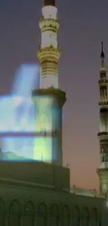 Mosque tower against twilight sky, beautifully illuminated.