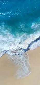 A stunning aerial view of ocean waves meeting sandy beach.