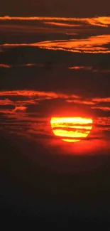 Vibrant sunset over calm ocean horizon with orange and black hues.