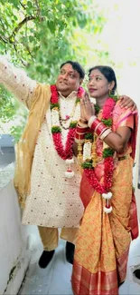 Couple in traditional wedding attire celebrating outdoors.