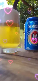 Beer glass and can with heart overlays under trees.