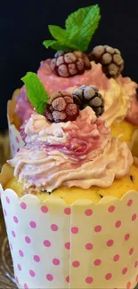 Cupcakes with berries and pink frosting, topped with mint leaves.