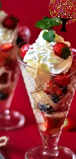 Ice cream cones with berries and mint on a red backdrop.