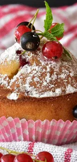 A fluffy berry muffin topped with fresh berries on a striped cloth.