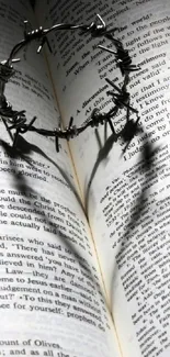 Open Bible with a heart shadow from a crown of thorns, symbolizing love and faith.