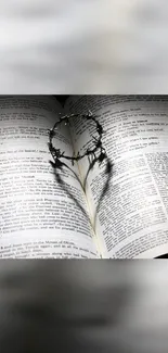 Open Bible with heart shadow made by a barbed wire loop, symbolizing faith and love.