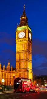 Night view of Big Ben with glowing lights and a red bus in London.