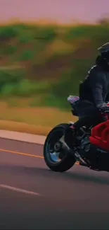 Motorcycle rider on an open road during sunset.