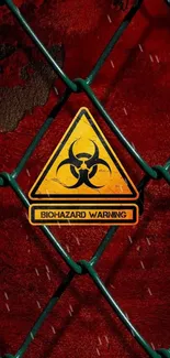 Biohazard warning sign on a red chain-link fence background.