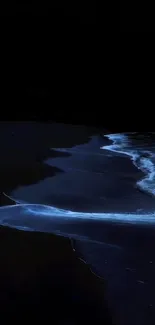 Glowing waves on a dark beach at night.