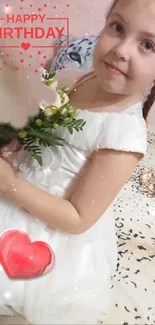 Smiling child in white dress holding flowers with birthday text and heart.