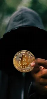 Mystery hooded figure holding a Bitcoin on a dark background wallpaper.