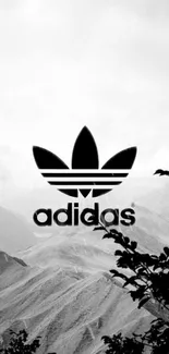 Black and white Adidas logo over mountain scenery.