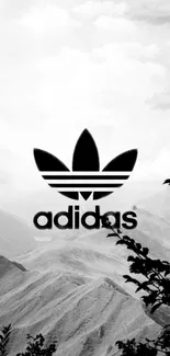 Black and white Adidas logo with mountain backdrop.