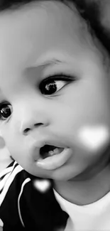 Black and white portrait of a baby with soft, innocent expression.