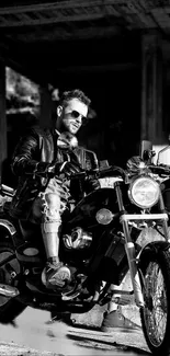 Black and white photo of a biker on a motorcycle wearing a leather jacket.