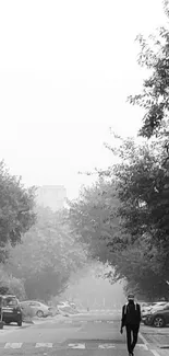 Black and white city street with lone figure walking.