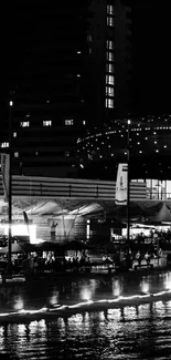 Black and white cityscape during night with reflections on water.