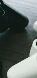 Black and white gaming controllers on wooden surface.