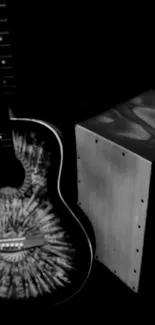 Black and white guitar alongside cajón art.