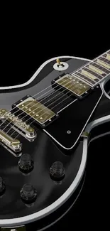 Glossy black electric guitar on dark background.